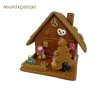 Fully assembled gingerbread house with gingerbread tree, decorated with chocolate pretzels and sugar figurines 