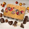 Gingerbread tin with Christmas ornaments, surrounded by gingerbread confectionery