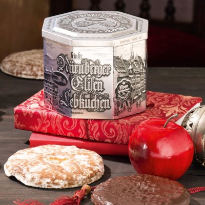 Silberdose auf Büchern und umgeben von Nürnberger Elisen Lebkuchen