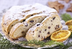 Christstollen auf Teller mit Zitronenscheibe und Tannenzweigen als Deko